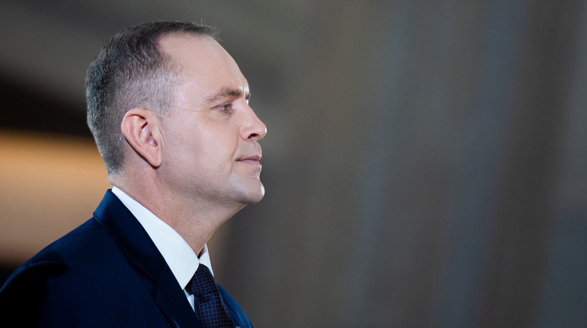 Кароль Навроцький під час промови на тлі червоно-чорного прапора